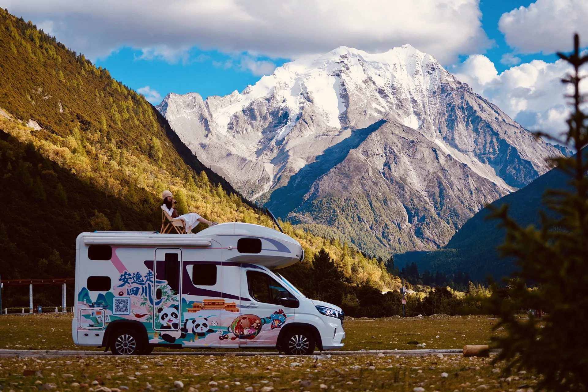 RV2GO campervan parked beneath dramatic snow-capped peaks on the Sichuan-Tibet route, China