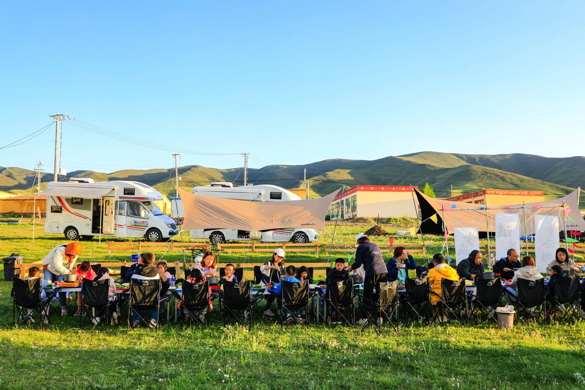 Travellers enjoying an outdoor meal at an RV2GO campsite on the grasslands of Qinghai, China